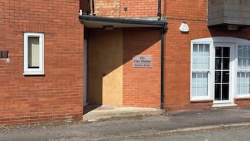 A brick building with a sign reading 'The Flat House Binden Road.'