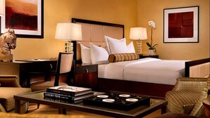 A hotel room with a bed, two bedside tables, a chair, a coffee table, and a bookshelf. - 1-Bedroom / 1BB / Suite at Trump International Hotel Las Vegas - F1 Weekend!!! (Las Vegas)