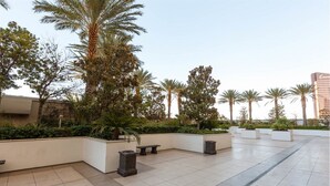 A spacious outdoor area with palm trees, planters, and a tiled floor. - 1-Bedroom / 1BB / Suite at Trump International Hotel Las Vegas - F1 Weekend!!! (Las Vegas)