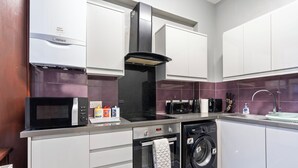 Uma cozinha moderna com micro-ondas, forno, lava-louças e exaustor preto.