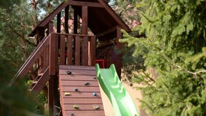 Eine Holzspielkonstruktion mit Rutsche und Klettergriffen.