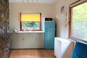 A compact kitchen with a window, a microwave, and a refrigerator. - Holiday Home With Fireplace and Large Terrace (Choczewo)