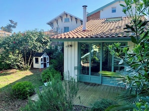 A house with a tiled roof, a glass door, and a small playhouse in the yard. - Little idyll in the heart of Cap Ferret A0309 (Lège-Cap-Ferret)