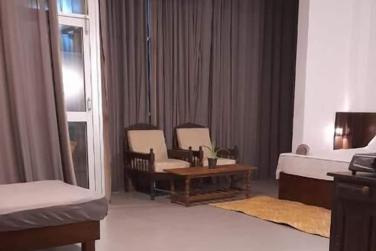 A modern room with a bed, a desk, and two chairs.