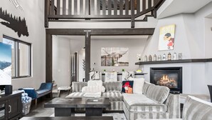 Ein modernes Wohnzimmer mit Kamin, einer Sofagarnitur, einem Couchtisch und einem Fernseher.