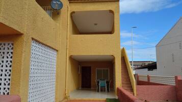 Un edificio con un porche cubierto, una puerta y una escalera.
