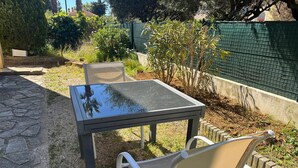 Eine Terrasse im Freien mit einem Tisch aus Glas und zwei Stühlen.