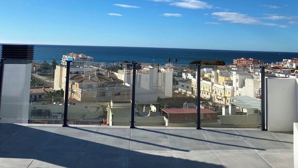 Eine Dachterrasse mit freiem Blick auf das Meer und die Gebäude.