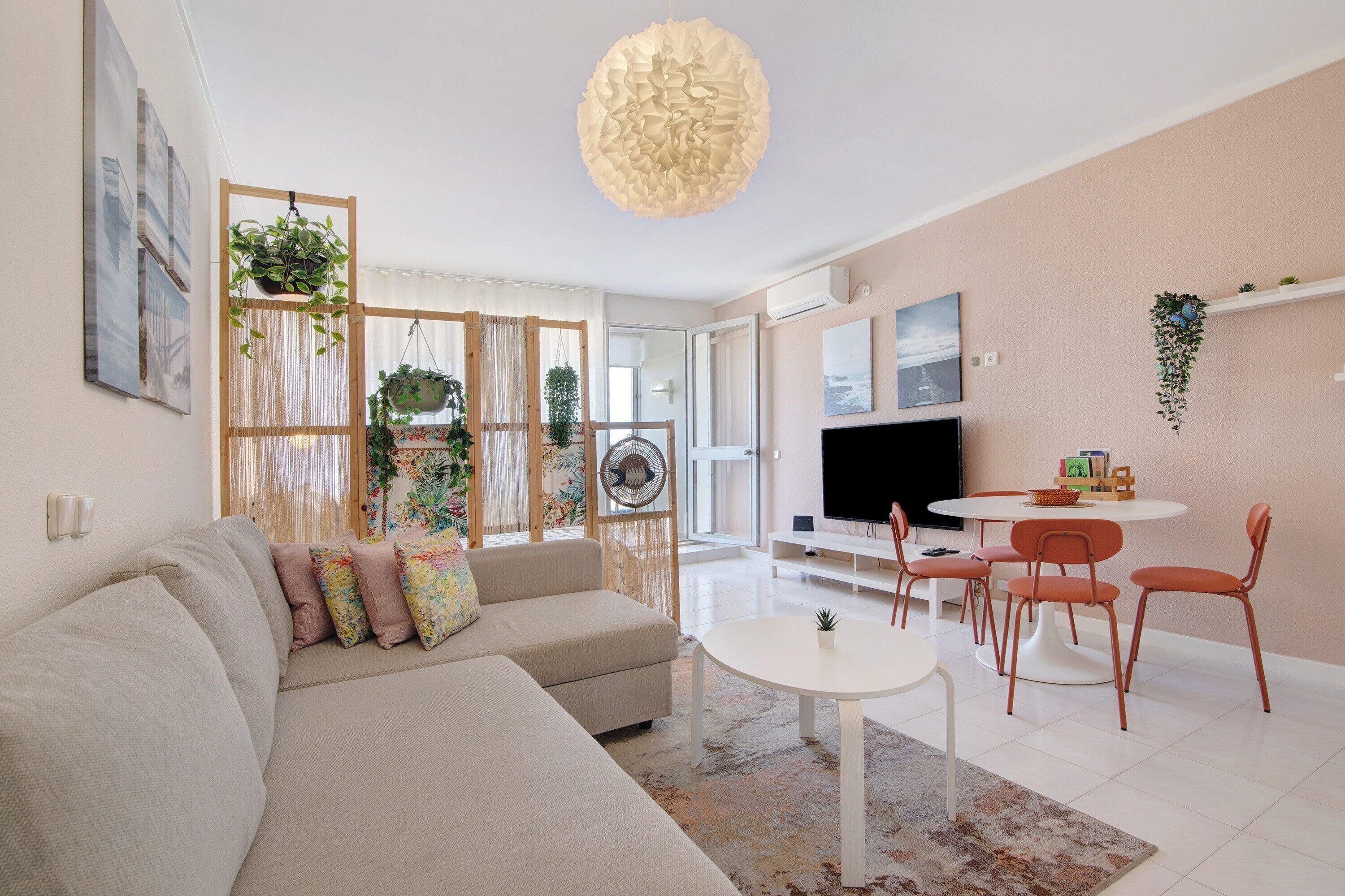 A modern living room with a sofa, a round table, and a TV.