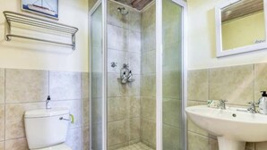 Ein Badezimmer mit Toilette, Duschkabine und Waschbecken.