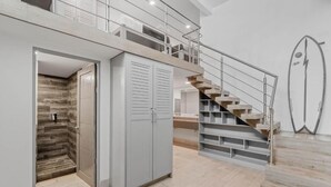 A modern interior with a staircase, a wardrobe, and a shower area. - Iguana Surf Boutique Hotel Tamarindo (Tamarindo)