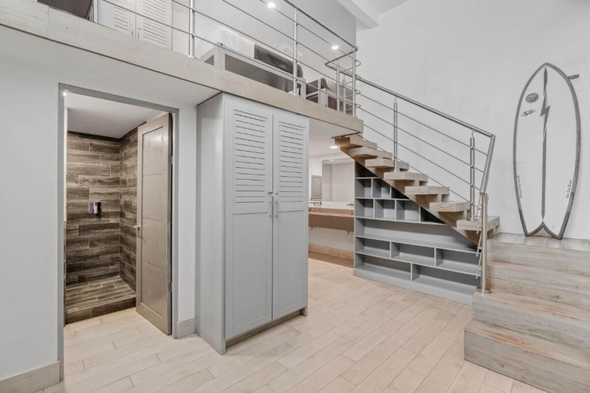 Un interior moderno con una escalera, un armario y una zona de ducha.