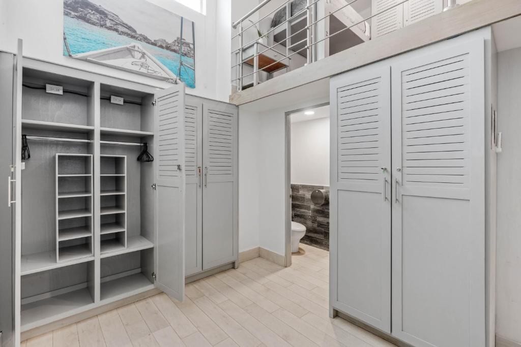 Ein modernes Interieur mit einem mehrstöckigen Kleiderschrank, einem Badezimmer mit Wandverkleidung aus Stein und einem Balkon mit Geländer.