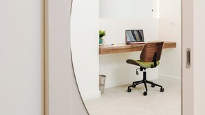 A room with a curved mirror reflecting a desk, chair, and a laptop. - Iguana Surf Boutique Hotel Tamarindo (Tamarindo)