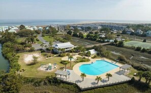 Ein Resort mit großem Schwimmbad, Tennisplatz und Meerblick.