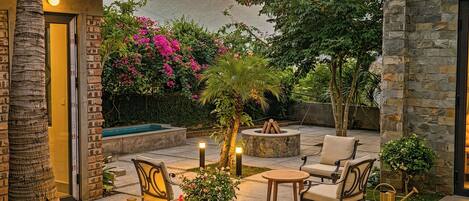 An outdoor patio with stone walls, a pool, and seating areas.
