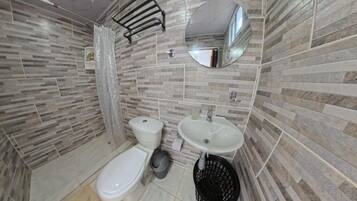 Un baño con inodoro, lavabo y espejo.