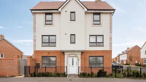 A two-story residential building with a symmetrical facade, a central entrance, and a brick lower section. - Modern 4BR Home 10 Beds Family-Friendly, Aylesbury (Bierton)