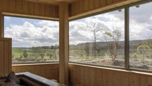 A room with wooden walls and large windows offering a view of a landscape. - Charming stone house in the heart of the Vexin, enclosed garden and view of the bell tower (Vaudancourt)