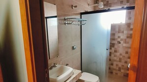 A bathroom with a sink, toilet, and shower. - Hotel Cardinal Pedro Juan Caballero (Pedro Juan Caballero)