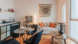 Un espace de vie compact comprenant une kitchenette, un coin repas et un coin salon.