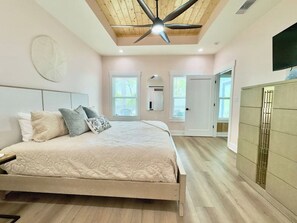 A bedroom with a bed, ceiling fan, and a wardrobe.