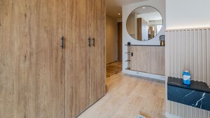 Une salle de bain moderne avec des meubles en bois, un miroir et un plan de toilette en marbre.