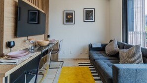 Un espace de vie moderne comprenant un coin cuisine, un canapé et une table à manger.