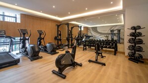 A gym with cardio machines, weightlifting equipment, and a mirror wall. - City-Core Loft w/ Terrace + Rooftop Views (Mexico City)