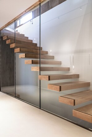 Eine moderne Treppe mit Glastrennläufen und Holzstufen.