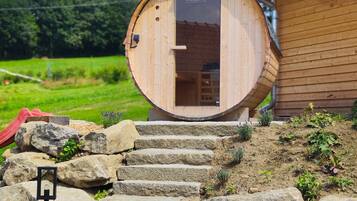 Une structure en bois sur laquelle est apposée une enseigne indiquant « KOME DELUXE », et un escalier en pierre menant à cette structure.