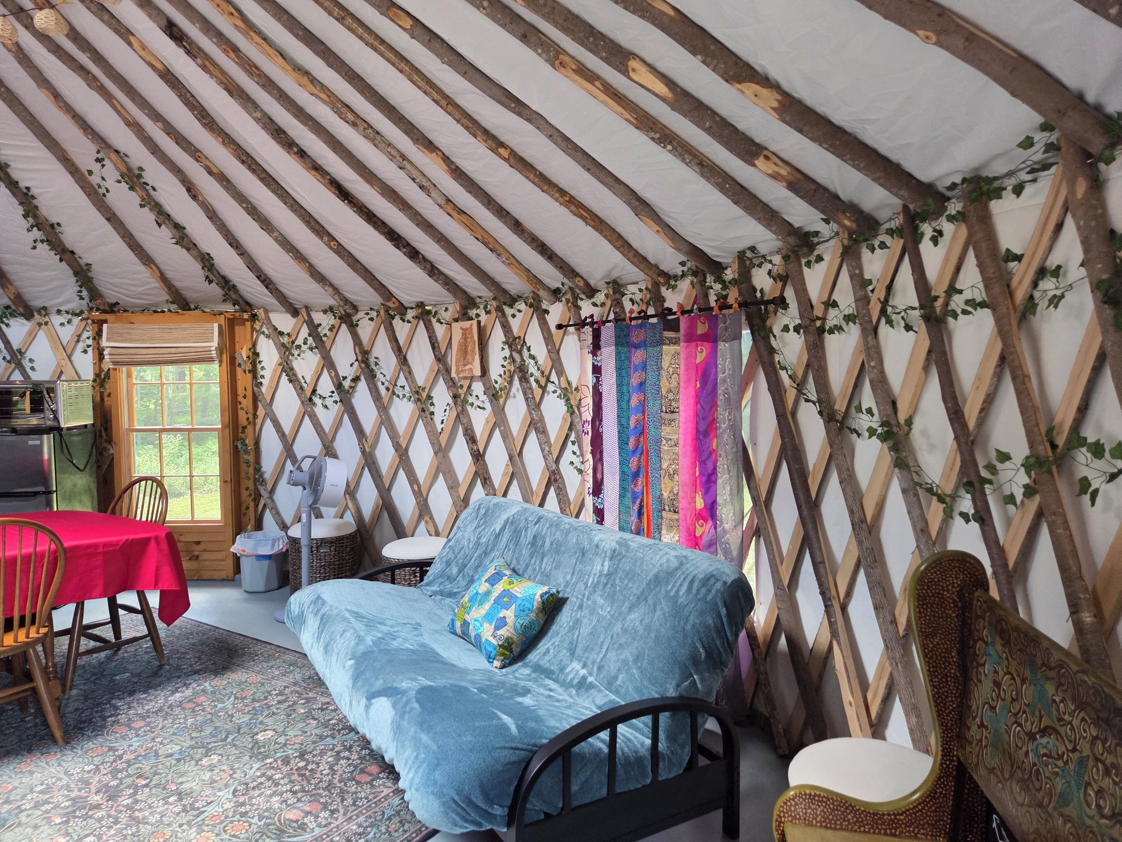 A cozy interior with a bed, a table, and chairs.