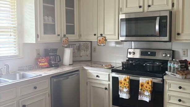 A kitchen with white cabinets, a microwave, an oven, and a dishwasher. - Beautiful 4-bedroom house in tranquil Jackson perfect for families (Jackson)