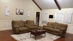 A living room with two brown sofas, a wooden coffee table, and a patterned rug. - Beautiful 4-bedroom house in tranquil Jackson perfect for families (Jackson)
