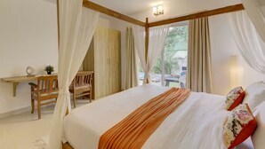A bedroom with a bed, a desk, a chair, and a window with curtains.