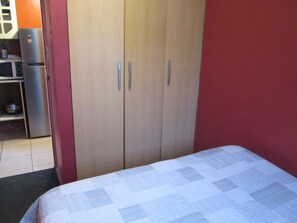 A bedroom with a bed, a wardrobe, and a kitchenette area. - B1 Comfortable furnished 1-story apartment near downtown Puerto Montt (Puerto Montt)