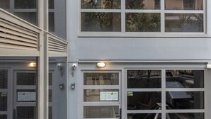A modern building with large windows, a glass door entrance, and a tiled floor.