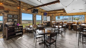 Un restaurante con paredes de madera, ventanas amplias y vista al mar.