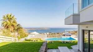 A modern outdoor patio with a pool, a white fence, and a view of the sea. - Seaview Villa Private Pool & BBQ, 1km from Elounda (Schisma Eloundas)