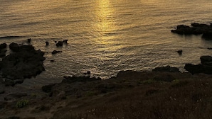 Un atardecer sobre un mar tranquilo con una isla distante.