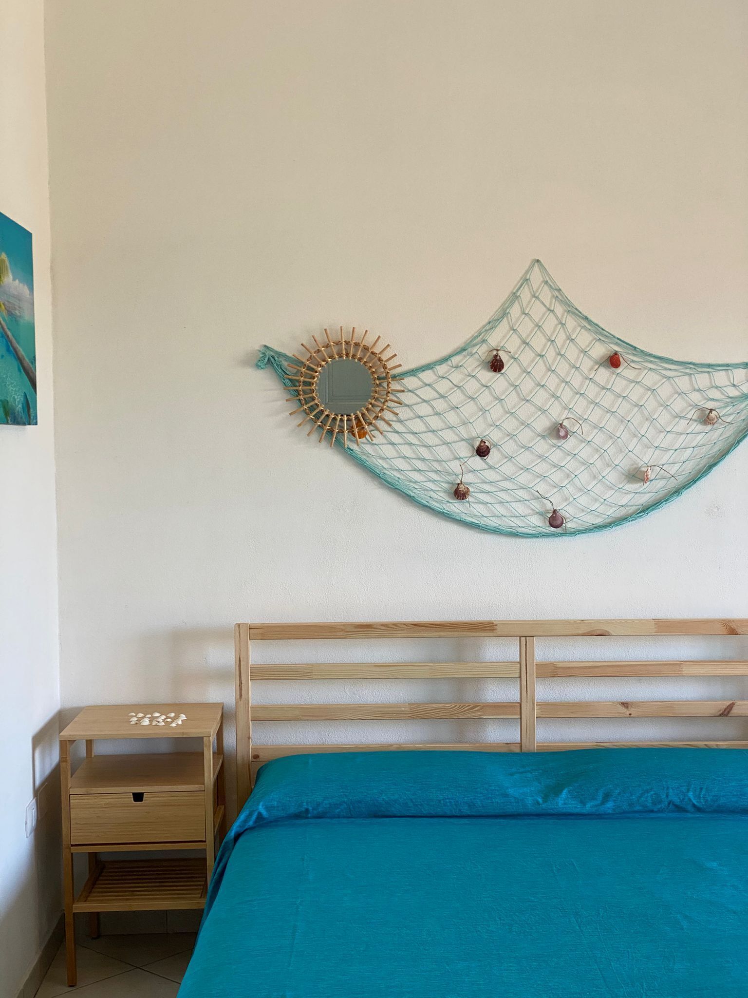 Ein Schlafzimmer mit einem Bett, einem Nachttisch aus Holz und einer Wanddekoration.