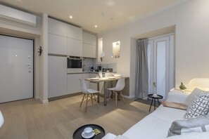 A compact living space with a kitchenette, a dining area, and a seating area with a sofa and a small table. - One-bedroom apartment on the first floor in the heart of Brera, Milan’s artistic and bohemian district. A strategic location just steps from the Pinacoteca di Brera, La Scala Theatre, and Castello Sforzesco.An elegant apartment offering all modern comf (Milan)