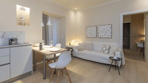 Een moderne woonkamer met een bank, een eettafel en een keukenhoek.