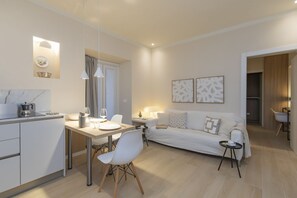 A modern living room with a sofa, a dining table, and a kitchen area. - One-bedroom apartment on the first floor in the heart of Brera, Milan’s artistic and bohemian district. A strategic location just steps from the Pinacoteca di Brera, La Scala Theatre, and Castello Sforzesco.An elegant apartment offering all modern comf (Milan)