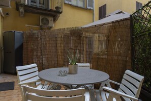 A round table with four chairs, a potted plant, and a small decorative item. - One-bedroom apartment on the first floor in the heart of Brera, Milan’s artistic and bohemian district. A strategic location just steps from the Pinacoteca di Brera, La Scala Theatre, and Castello Sforzesco.An elegant apartment offering all modern comf (Milan)