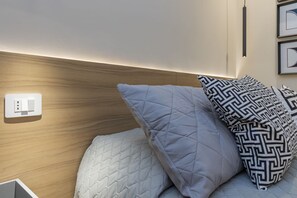A neatly made bed with a quilted headboard, a bedside switch, and a wall-mounted light fixture. - One-bedroom apartment on the first floor in the heart of Brera, Milan’s artistic and bohemian district. A strategic location just steps from the Pinacoteca di Brera, La Scala Theatre, and Castello Sforzesco.An elegant apartment offering all modern comf (Milan)