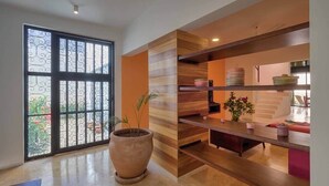 A modern interior with a large window, a wooden bench, and a potted plant. - Casa Chopin Stylish Home in Santiago (Mérida)