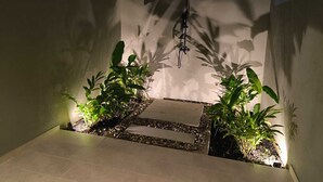 A narrow outdoor corridor with tiled flooring, two potted plants on either side, and a hanging light fixture. - Large Farm via Villeta in Closed Condominium (Villeta)
