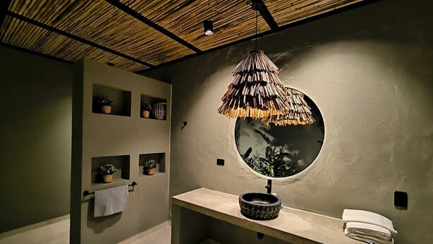 A bathroom with a round mirror, a shelf with a towel, and a hanging lamp. - Large Farm via Villeta in Closed Condominium (Villeta)