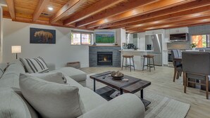 Un amplio espacio habitable con chimenea, una cocina y un comedor.